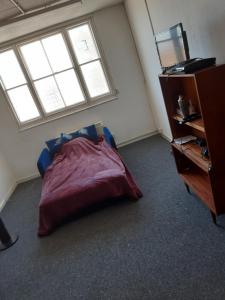 a bedroom with a bed and a desk and windows at VOB Enterprises in Chatham