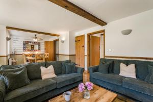 a living room with two couches and a table at Moorhens in Somerford Keynes
