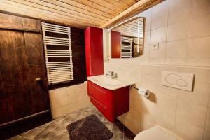a bathroom with a red cabinet and a sink at Chalet Louchelet in Hérémence +7 photos