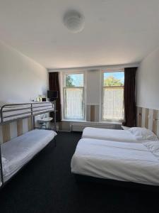a hotel room with two beds and two windows at hotel Oosterpark in Amsterdam