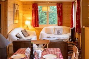 a living room with two white couches and a window at Chalet Les Rhodos in Vex