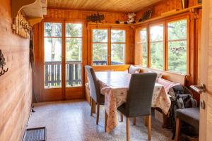 a dining room with a table and chairs and windows at Chalet Les Rhodos in Vex +12 photos
