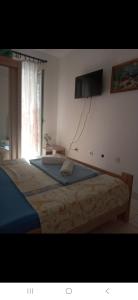 ein Schlafzimmer mit einem Bett und einem Fernseher an der Wand in der Unterkunft Zagaa1 in Petrovac na Moru