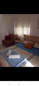 ein Wohnzimmer mit einem Bett und einer Couch in der Unterkunft Zagaa1 in Petrovac na Moru