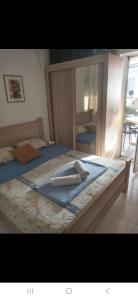 ein Schlafzimmer mit einem großen Bett und einem Spiegel in der Unterkunft Zagaa1 in Petrovac na Moru