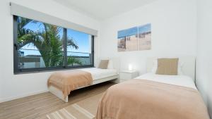 a bedroom with two beds and a large window at Villa Calhau by LovelyStay in Ponta do Sol