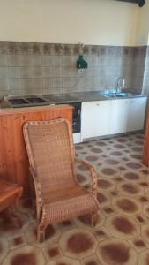 a kitchen with a chair and a stove and a sink at Casa Rosmarina in Pieve di Soligo