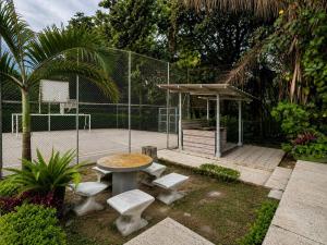 a tennis court with a table and benches and a basketball hoop at Espectacular Apto in Ibagué