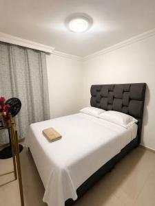 a bedroom with a large bed with a black headboard at Espectacular Apto in Ibagué +5 photos