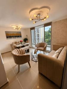 a living room with a couch and chairs and a table at Espectacular Apto in Ibagué