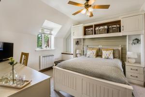 a bedroom with a bed with a ceiling fan at Moorhens in Somerford Keynes