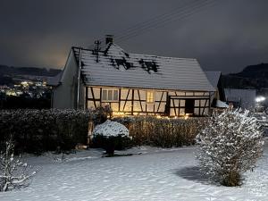 a house with a snow covered roof in a yard at B&B Heckerfeld in Burglahr