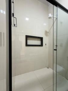 a glass shower in a bathroom with a sink at Casa 02 - Aconchegante e cheia de estilo - 5 min do centro in Alta Floresta