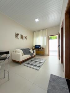 a white living room with a couch and a table at Casa 02 - Aconchegante e cheia de estilo - 5 min do centro in Alta Floresta