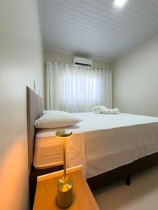 a small bedroom with a bed and a table at Casa 02 - Aconchegante e cheia de estilo - 5 min do centro in Alta Floresta