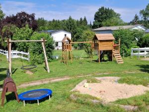 a playground with a tree house and a swing at Mitteltalhof in Kaufungen