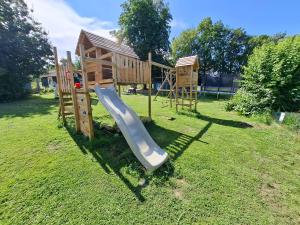 a playground with a slide in the grass at Mitteltalhof in Kaufungen