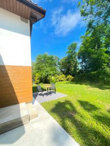 a patio with a table and chairs in a park at Akacjowe Wzgórze in Ruciane-Nida