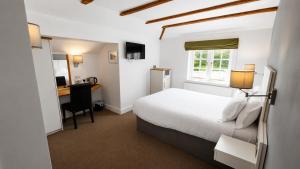 a bedroom with a bed and a desk with a computer at The Fox at Ibstone in High Wycombe