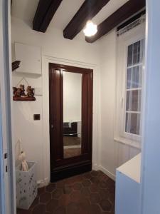 a hallway with a wooden door and a window at Cottage spirit in Normandy - typical studio in Évreux
