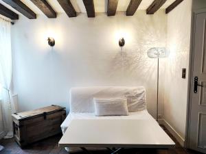 a bedroom with a white bed and a lamp at Cottage spirit in Normandy - typical studio in Évreux