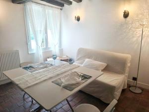 a living room with a white couch and a table at Cottage spirit in Normandy - typical studio in Évreux +5 photos