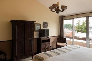 a bedroom with a bed and a tv on a cabinet at Hostal Villa Toscana in Guatemala