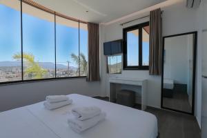 a bedroom with two towels on a bed with windows at Hotel Olserd in Ksamil +130 photos