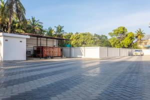 an empty street with a fence and a building at Hotel Saesha International in Rāmeswaram