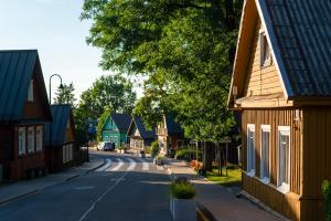 an empty street in a small town with houses at Historic Karaimai Street Balcony Apartment, Trakai, Lithuania in Trakai