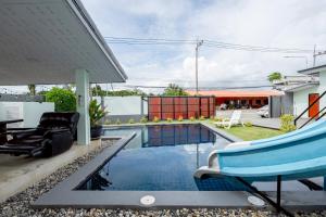 a swimming pool in a backyard with a house at Blue Lake Residences - Pattaya in Nong Prue