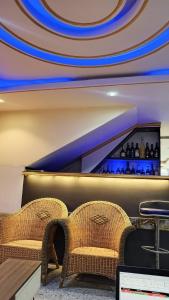 a restaurant with two wicker chairs and a bar at MB California Guest House in Bonabéri