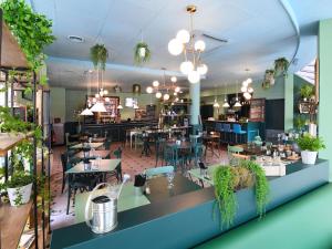 a dining room with tables and chairs and a restaurant at ibis Nantes Saint Herblain in Saint-Herblain