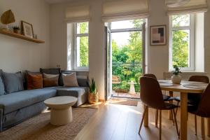 a living room with a couch and a table at Historic Karaimai Street Balcony Apartment, Trakai, Lithuania in Trakai
