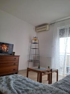 a bedroom with a bed and a table and a dresser at Zmaj LUX 2 in Mladenovac