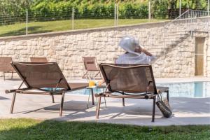 a person sitting in a chair talking on a cell phone at Residence La Vigna in Arco