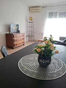 a table with a pot of flowers on top of it at Zmaj LUX 2 in Mladenovac +4 photos