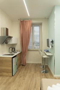 a kitchen with a sink and a desk in a room at Na Suite QuartieriSpagnoli in Naples