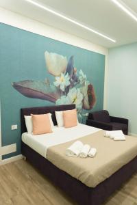 a bedroom with a bed with a painting on the wall at Na Suite QuartieriSpagnoli in Naples
