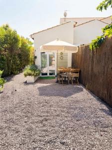 a patio with a table and an umbrella at Gite du paradis in Le Luc