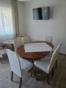 a dining room table and chairs with a wooden table at Apartment Kristijan in Pag