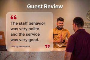 a man standing next to a sign that says guest review at Hotel O Parao Formerly Cozy Inn in Ajmer
