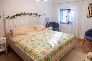 a bedroom with a large bed with two blue chairs at Casa de Sume in Monte da Pedra +18 photos