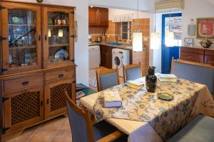 a kitchen with a table with chairs and a dining room at Casa de Sume in Monte da Pedra