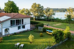 a white house with a yard with a boat on it at Un Occhio Sul Lago in Dormelletto
