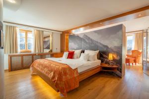 a bedroom with a bed with a large painting on the wall at Hotel Franks in Oberstdorf +46 photos
