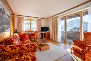 a living room with a couch and a large window at Hotel Franks in Oberstdorf