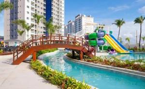a bridge over a pool with a water slide at Salinas Exclusive Resort in Salinópolis