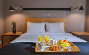 bandeja de comida en una cama con bebidas y fruta en Phaedra Apartment, en Atenas