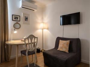 a room with a desk and a chair and a table at Casa das Hortênsias - Charming Guest House in Sintra